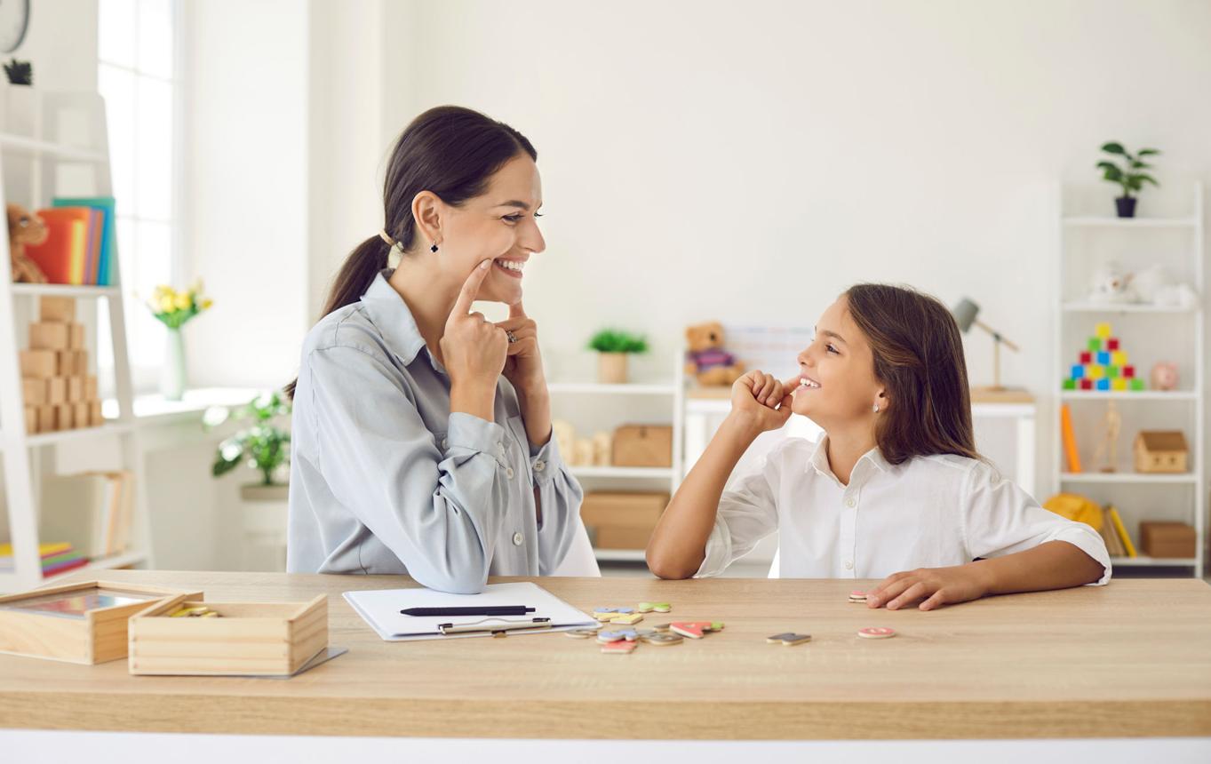 Speech-language pathologist modeling therapy techniques with a student.